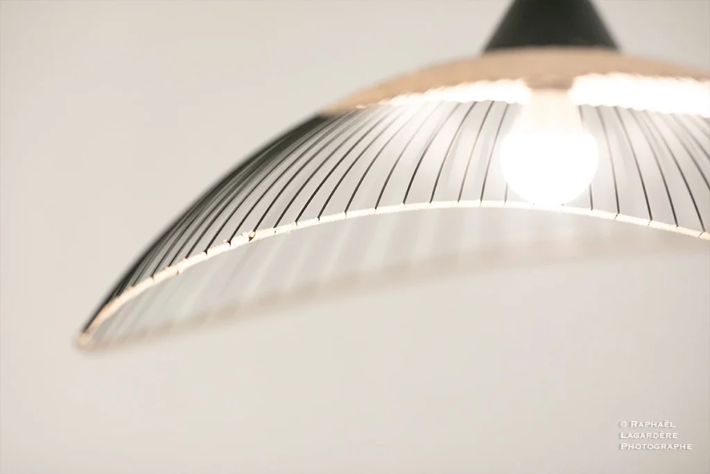 Lámpara decorativa moderna iluminada, utilizada para ilustrar la sección de Información Útil del Hôtel Porte du Bassin.